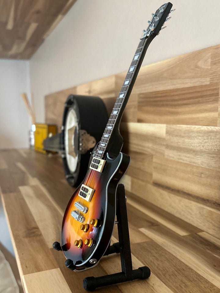miniature Slash replica guitar on a wooden surface on a stand