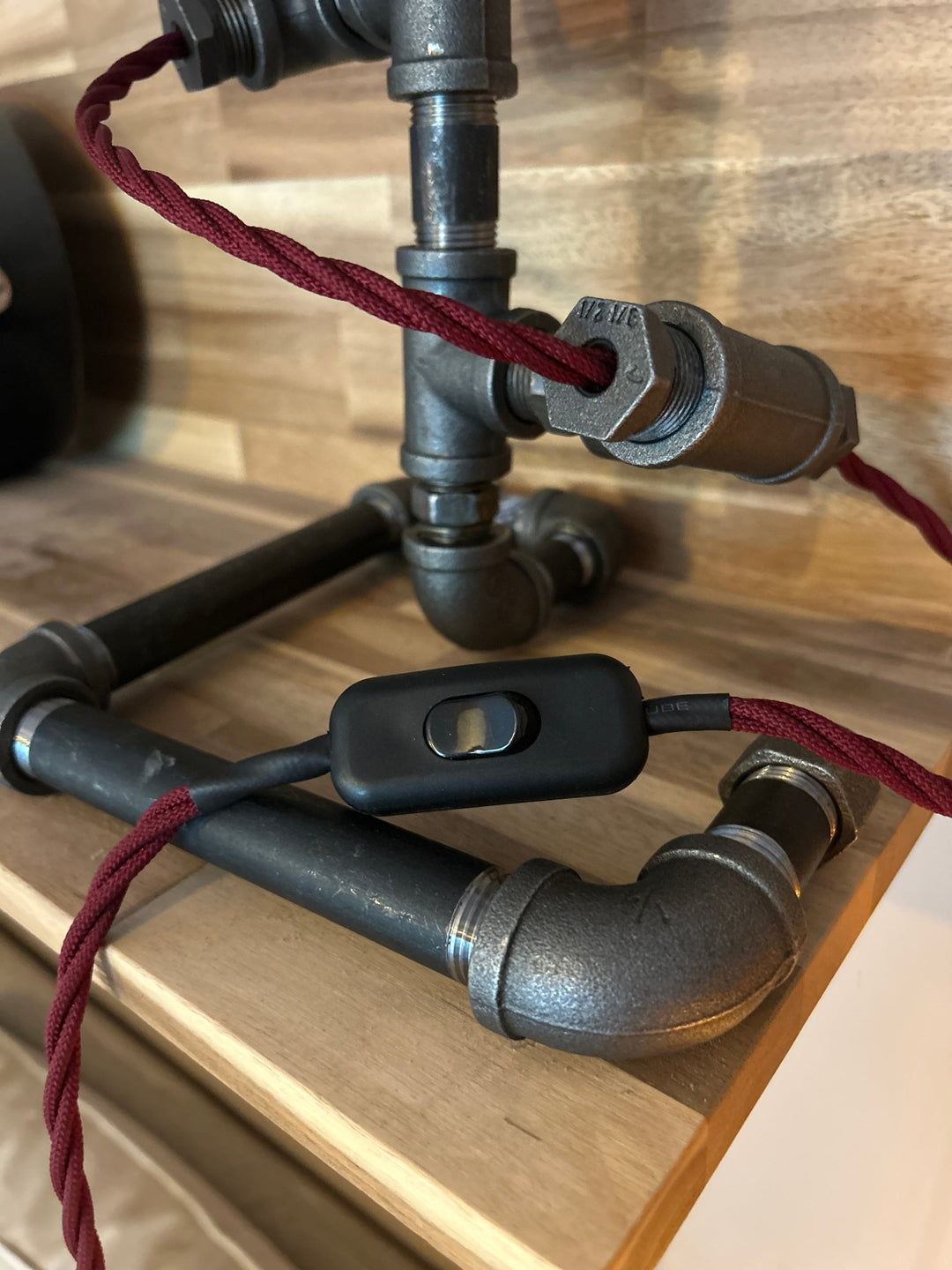 cord detail of Pipework Lamp with braided burgundy cord spiralling around the lamp 