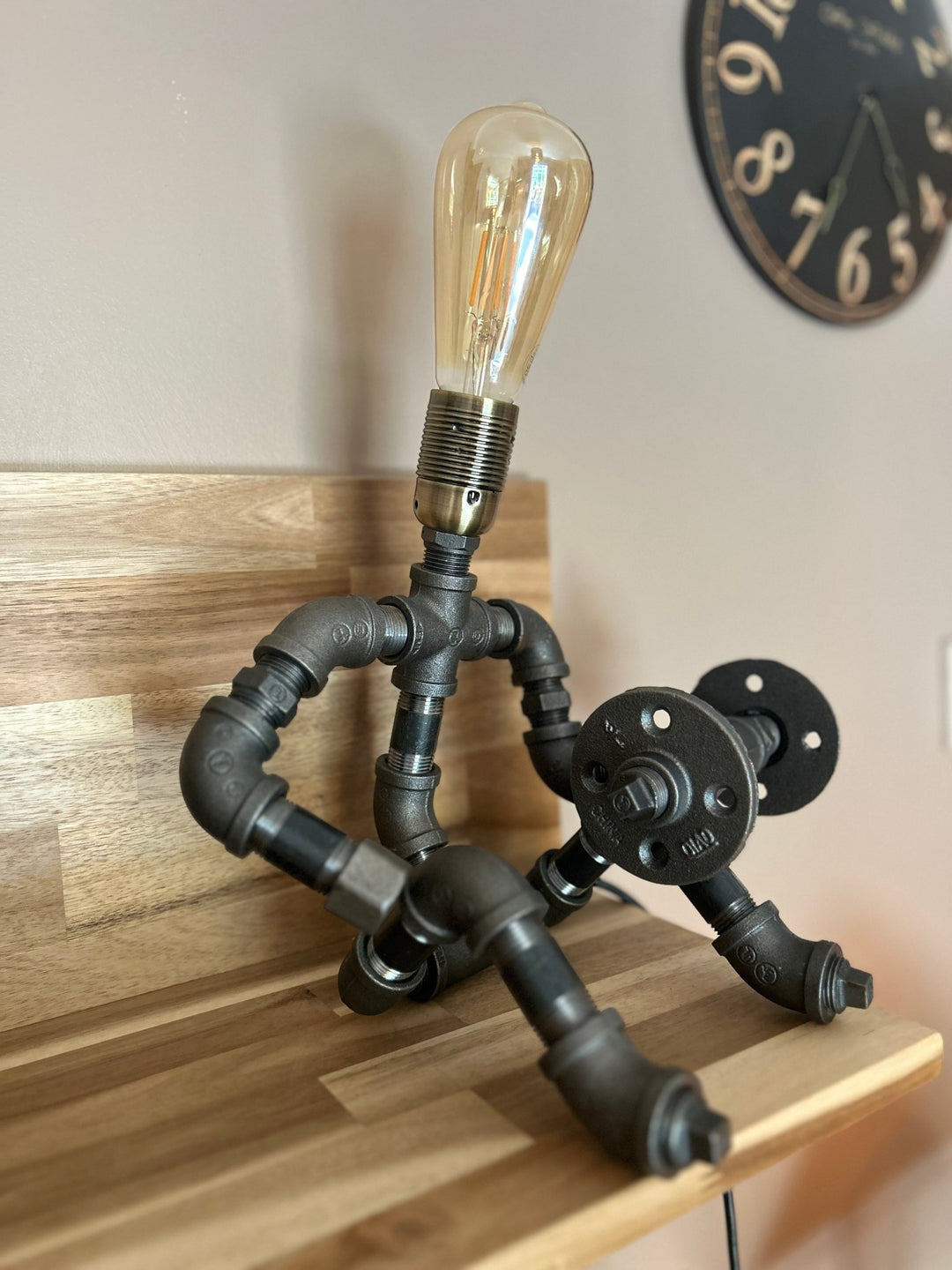 Industrial-style pipework table lamp in stance of a weightlifter with dumbbell