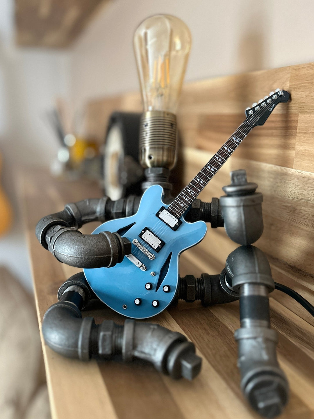 Pipework Guitar lamp holding a Foo Fighters inspired miniature guitar