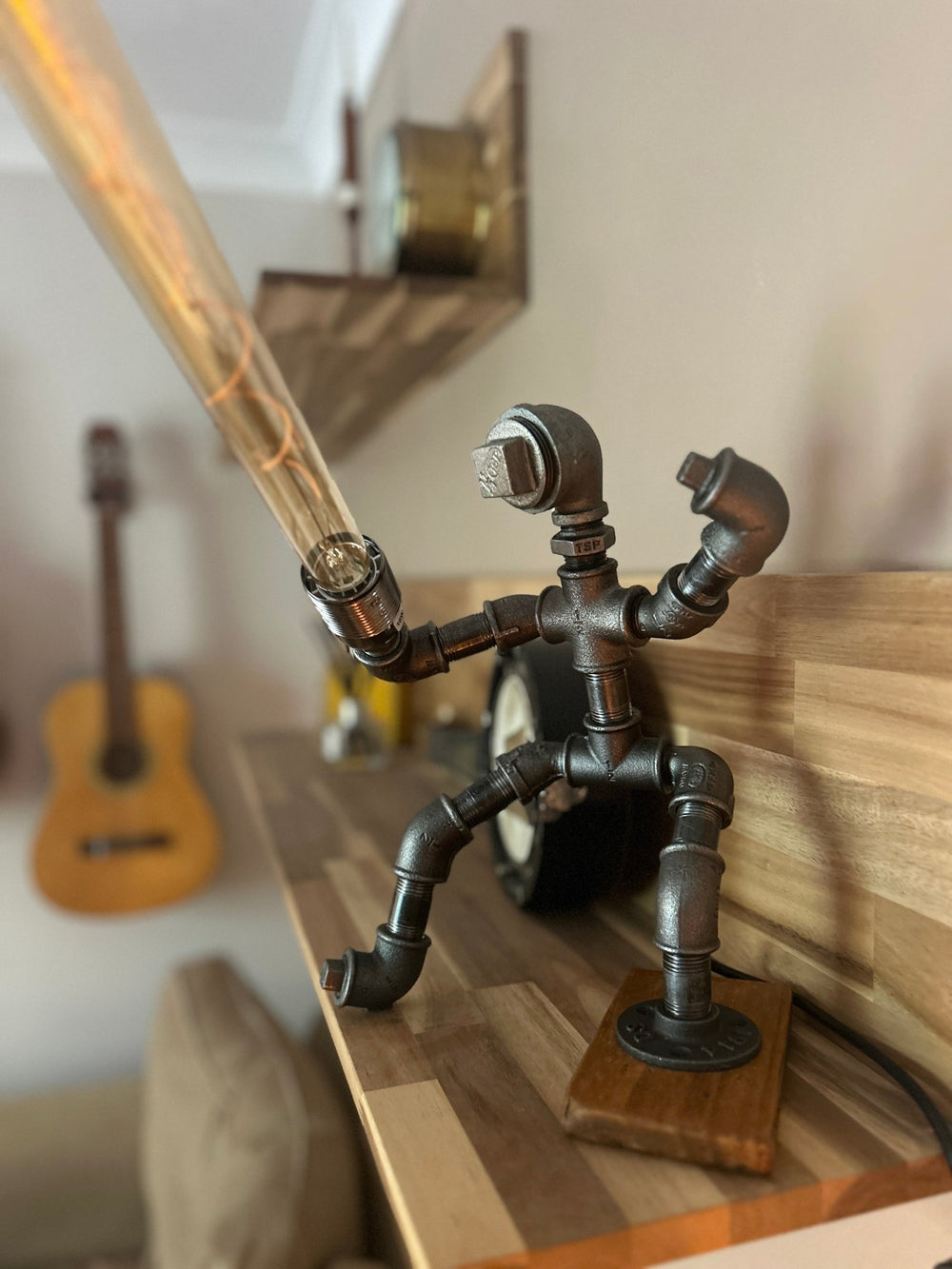 Decorative pipework lamp in the stance of a Jedi Knight holding a long bulb to imitate a lightsaber