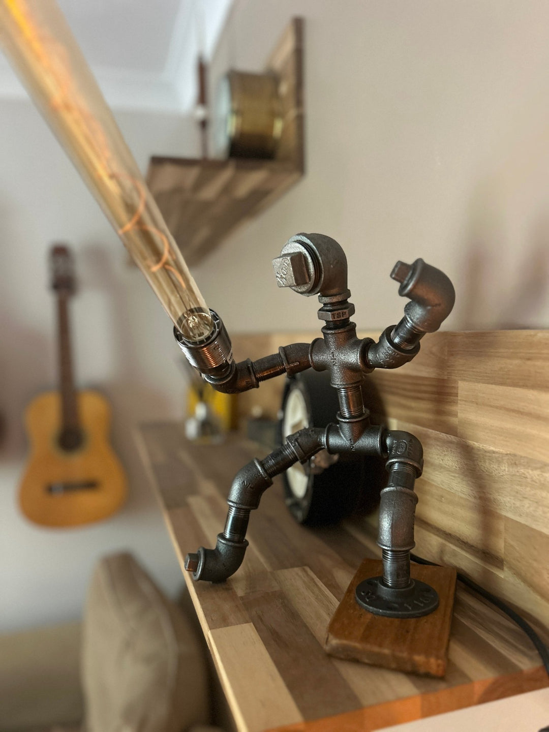 Decorative pipework lamp in the stance of a Jedi Knight holding a long bulb to imitate a lightsaber
