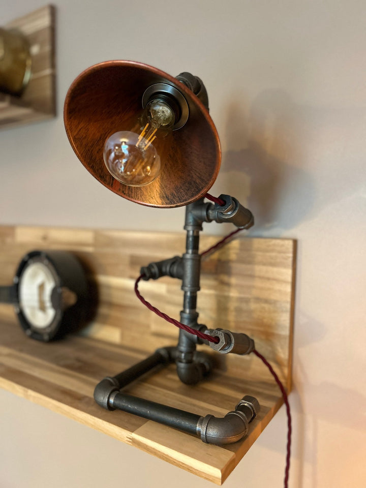 Bulb detail of Pipework Lamp with braided burgundy cord spiralling around the lamp 