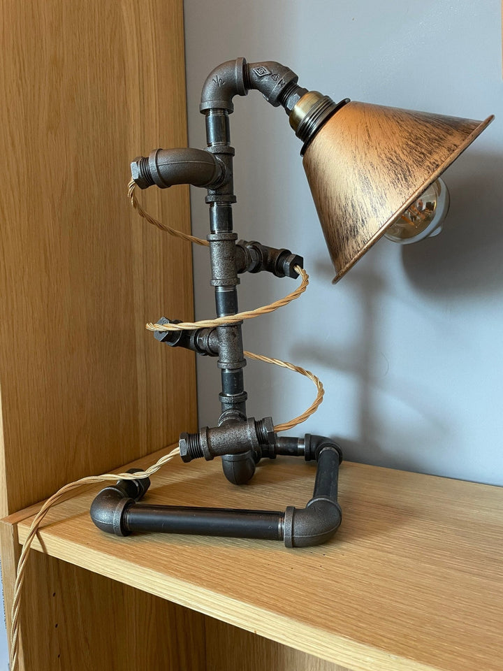 Industrial-style pipework lamp with gold braided cable spiralling around the lamp